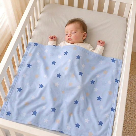 Bébé endormi dans son lit à barreaux, recouvert d'une couverture bleu clair à étoiles
